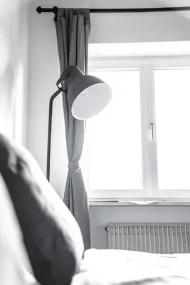 a lamp in a bedroom next to a window at Apartment Schoenblick in Caldaro