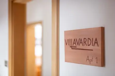 a sign on a wall next to a door at Apartments Villa Vardia in Caldaro