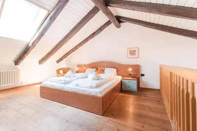 a bedroom with a large bed and a wooden floor at Apartments Ansitz Wieshof in Castelvecchio