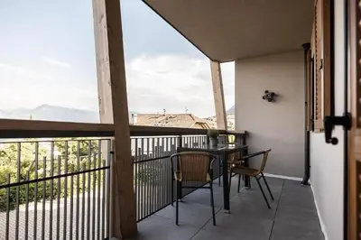 a balcony with a table and chairs and a view at Apartments Hofgarten in Caldaro