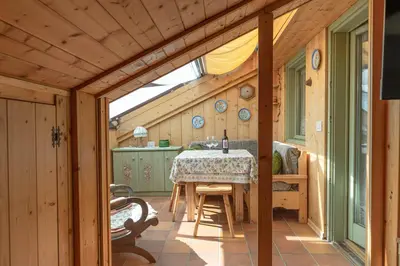 a kitchen with a table in a wooden house at Private Veranda - Tiroler Chalet - Near Ski Slopes & Dolomites in Carano