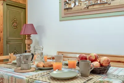 a table with a basket of fruit and orange juice at Private Veranda - Tiroler Chalet - Near Ski Slopes & Dolomites in Carano