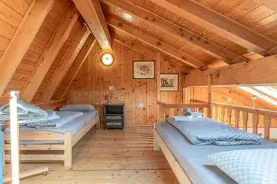 a bedroom with two beds in a wooden cabin at Private Veranda - Tiroler Chalet - Near Ski Slopes & Dolomites in Carano