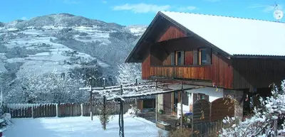a house covered in snow with a mountain in the background at Tommele Hof in Volser Aicha