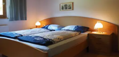 a large bed with two blue pillows on it at Tommele Hof in Volser Aicha