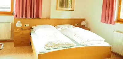 a bed with two pillows on it in a room at Tommele Hof in Volser Aicha