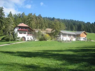 a large house in the middle of a green field at Laerchhof in Collalbo