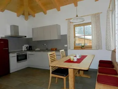 a kitchen with a wooden table with chairs and a table and a kitchen at Laerchhof in Collalbo