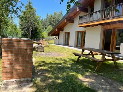 a picnic table in front of a house at Eco Chalet Nonno Silvano in Bedollo