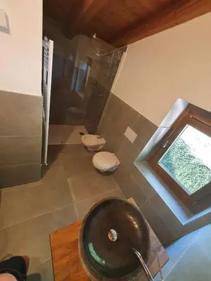 a bathroom with a sink and a toilet and a window at Eco Chalet Nonno Silvano in Bedollo