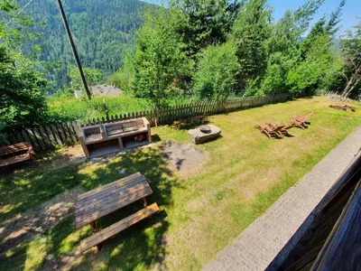 a park with two benches and a picnic table at Eco Chalet Nonno Silvano in Bedollo