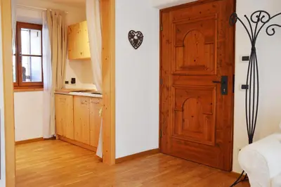 a kitchen with a wooden door in a room at Lüch dl Mone y Chalets in Badia