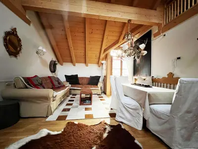 a living room with a couch and a table at Lüch dl Mone y Chalets in Badia