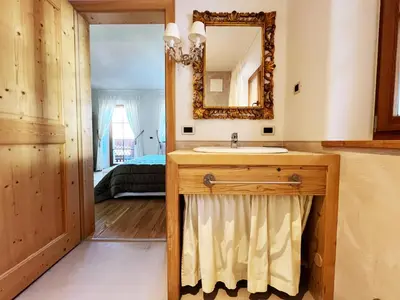 a bathroom with a sink and a mirror at Lüch dl Mone y Chalets in Badia