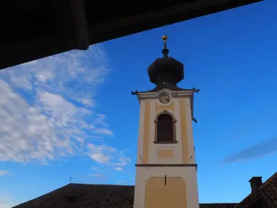 a clock tower with a blue sky in the background at Saint Martin Guest House in Cornaiano