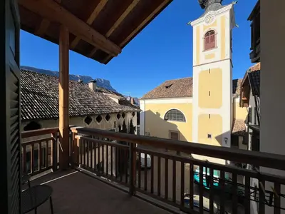 a view from the balcony of a building with a clock tower at Saint Martin Guest House in Cornaiano