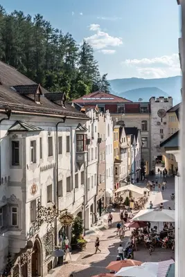 a group of people walking around a town with buildings at apartment beletage in San Lorenzo di Sebato