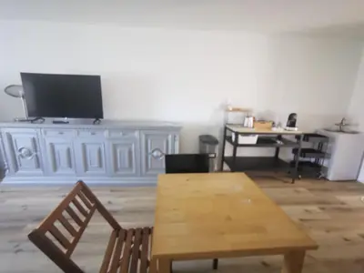 a living room with a wooden table and a tv at Casa della Lavanda in Sarnonico