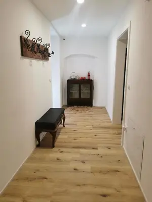 a hallway with a black ottoman on a wooden floor at Casa della Lavanda in Sarnonico