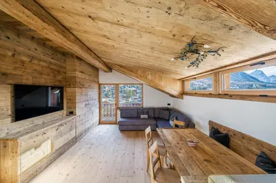 a living room with a table and a couch at Chalet Ronco - Dolomiti Skyline in Cortina dʼAmpezzo