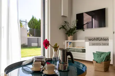 a glass table with a coffee pot and cups on it at Apartments LIANA in Postal