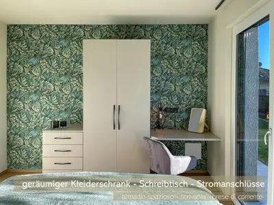 a bedroom with a white cabinet and a chair at Apartments LIANA in Postal