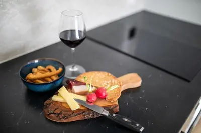 a table with a plate of food and a glass of wine at Apartments LIANA in Postal