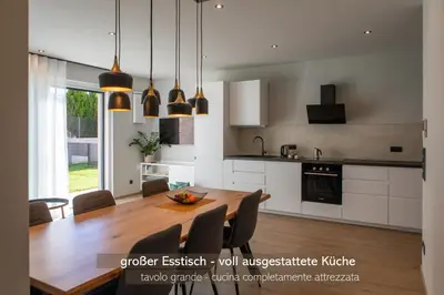 a kitchen with a wooden table and a dining room at Apartments LIANA in Postal