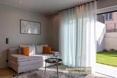 a living room with a couch and a large window at Apartments LIANA in Postal