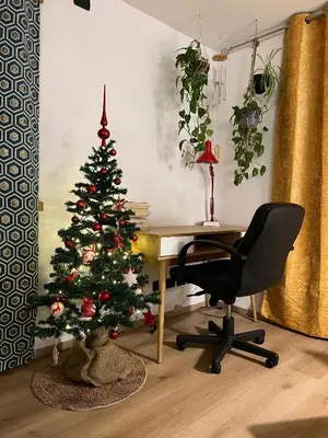 a christmas tree sitting next to a desk with a chair at Casa Carlotta Tesero-Relax and view in Tesero
