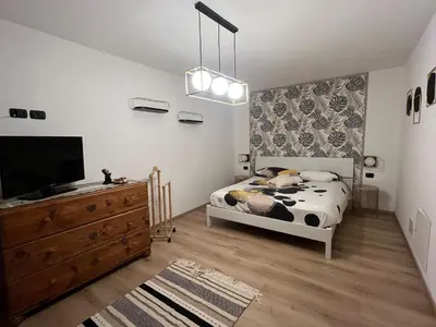 a bedroom with a bed and a flat screen tv at Casa Carlotta Tesero-Relax and view in Tesero