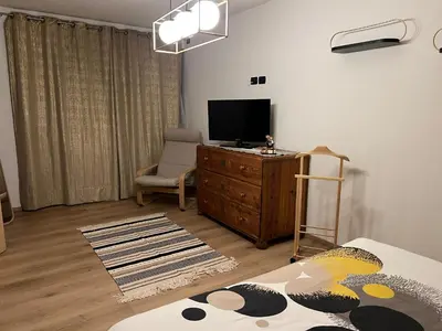 a living room with a television and a chair at Casa Carlotta Tesero-Relax and view in Tesero