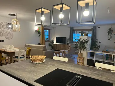 a kitchen and living room with a table and chairs at Casa Carlotta Tesero-Relax and view in Tesero