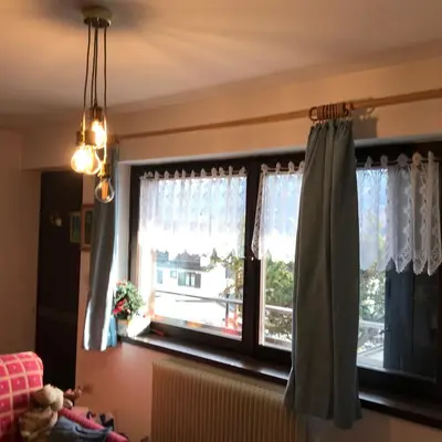 a window with curtains and a radiator in a room at Suite Marco nice apartment in Cavalese with View in Cavalese