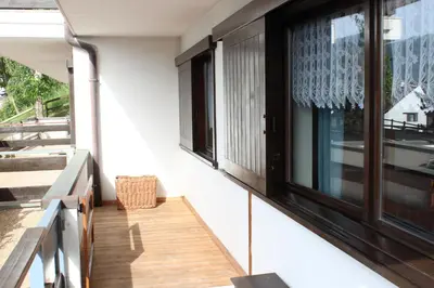 a balcony with black windows on a house at Suite Marco nice apartment in Cavalese with View in Cavalese