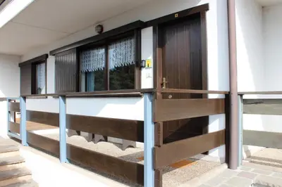a building with a wooden gate and windows at Suite Marco nice apartment in Cavalese with View in Cavalese