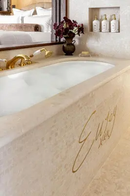 a bath tub in a hotel room with a bed at Ancora Cortina - The Leading Hotels of the World in Cortina dʼAmpezzo