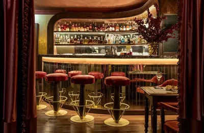 a bar with a bunch of stools in a room at Ancora Cortina - The Leading Hotels of the World in Cortina dʼAmpezzo