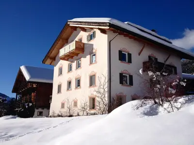 a building in the snow with a balcony at Sule Hof Agriturismo in Ortisei