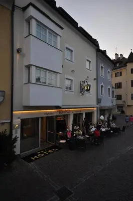 a group of people sitting at tables outside of a building at Cityhotel Tallero in Bressanone