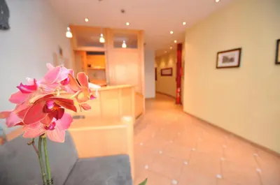 a vase with a pink flower in a room at Cityhotel Tallero in Bressanone