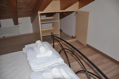 a room with a bed with white towels on it at Meraviglioso Loft con vista sulle Dolomiti in Colle Santa Lucia