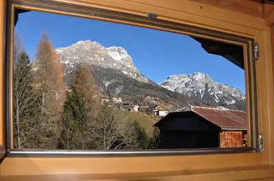a view of a mountain from a window at Meraviglioso Loft con vista sulle Dolomiti in Colle Santa Lucia
