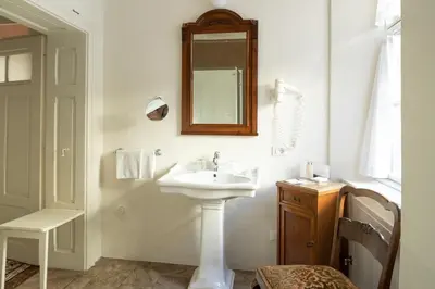 a white bathroom with a sink and a mirror at Villa Bergmann Suites Meran in Merano