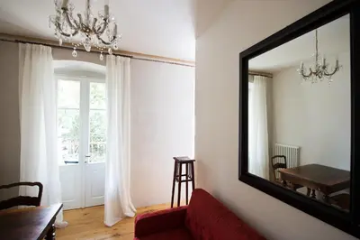 a living room with a red couch and a mirror at Villa Bergmann Suites Meran in Merano