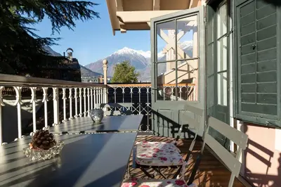 a balcony with a bench and a view of mountains at Villa Bergmann Suites Meran in Merano