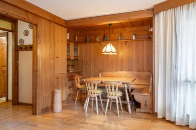 a dining room with a table and chairs at Cozy 3 bedroom with access to garden in Cortina dʼAmpezzo