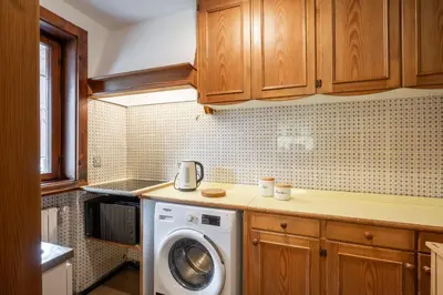 a kitchen with a washing machine on a counter at Cozy 3 bedroom with access to garden in Cortina dʼAmpezzo