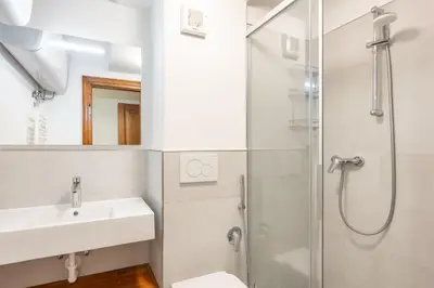 a white bathroom with a sink and a shower at Cozy 3 bedroom with access to garden in Cortina dʼAmpezzo