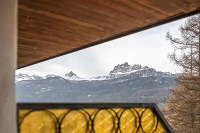 a view of a mountain range from a window at Cozy 3 bedroom with access to garden in Cortina dʼAmpezzo